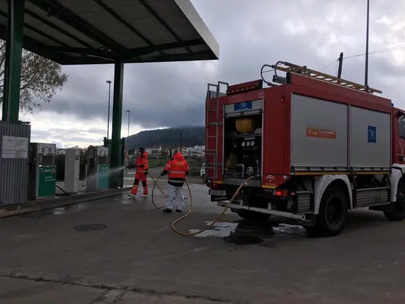 Bomberos desinfectando una gasolinera